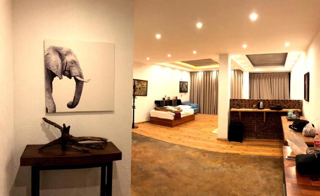 Jacky's Guesthouse في يوانيانغ: غرفة معيشة مع صورة الفيل على الحائط