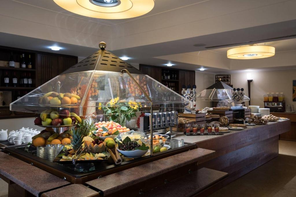 a buffet line with fruits and vegetables on display at Artemis Hotel in Cefalù