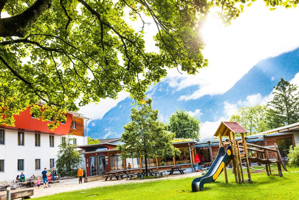 a playground in a park with mountains in the background at Jugendherberge Garmisch-Partenkirchen in Garmisch-Partenkirchen