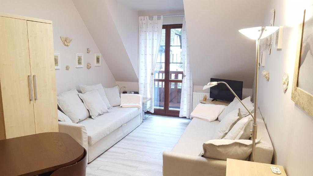 a living room with a white couch and a table at Apartment 32 Bombonierka Pod Aniołem in Kazimierz Dolny