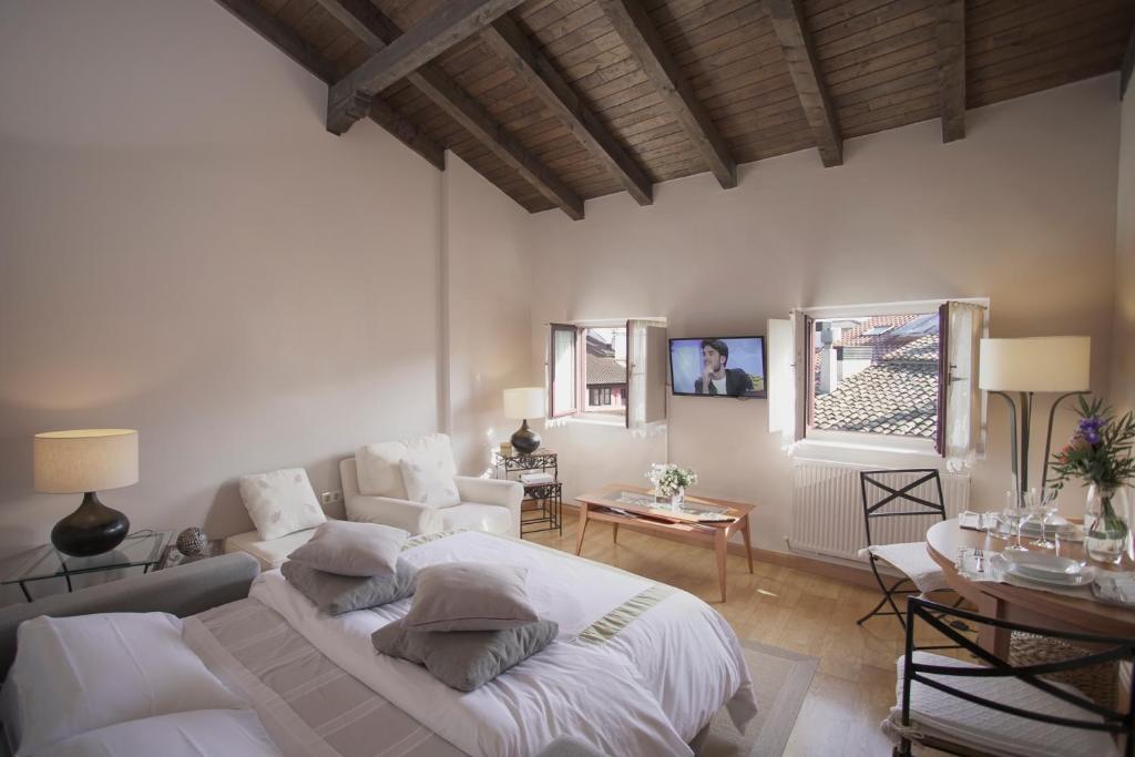 a living room with a white bed and a table at Altalea in Pamplona