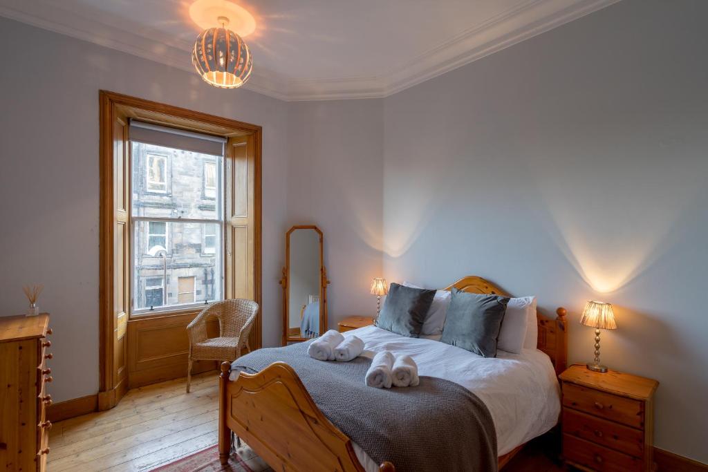 a bedroom with a bed with two stuffed animals on it at Edinburgh Serviced Apartment in Edinburgh