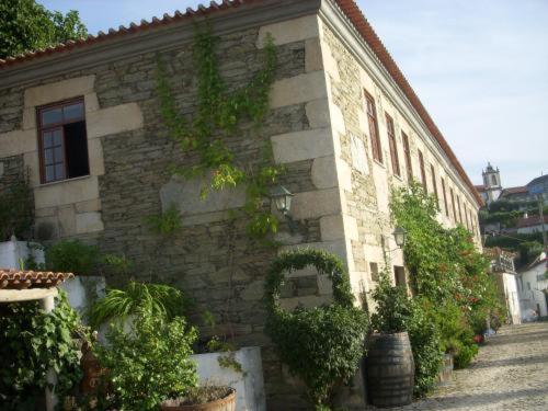 un edificio de piedra con plantas a su lado en Quinta Da Azenha, en Folgosa