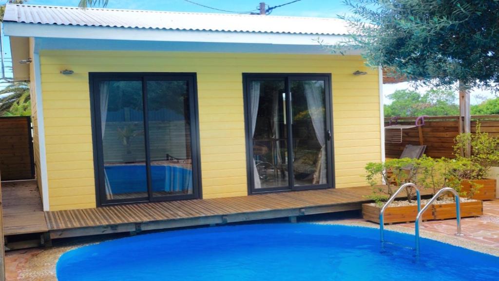 a yellow house with a pool in front of it at Charmant Bungalow in Saint-Pierre