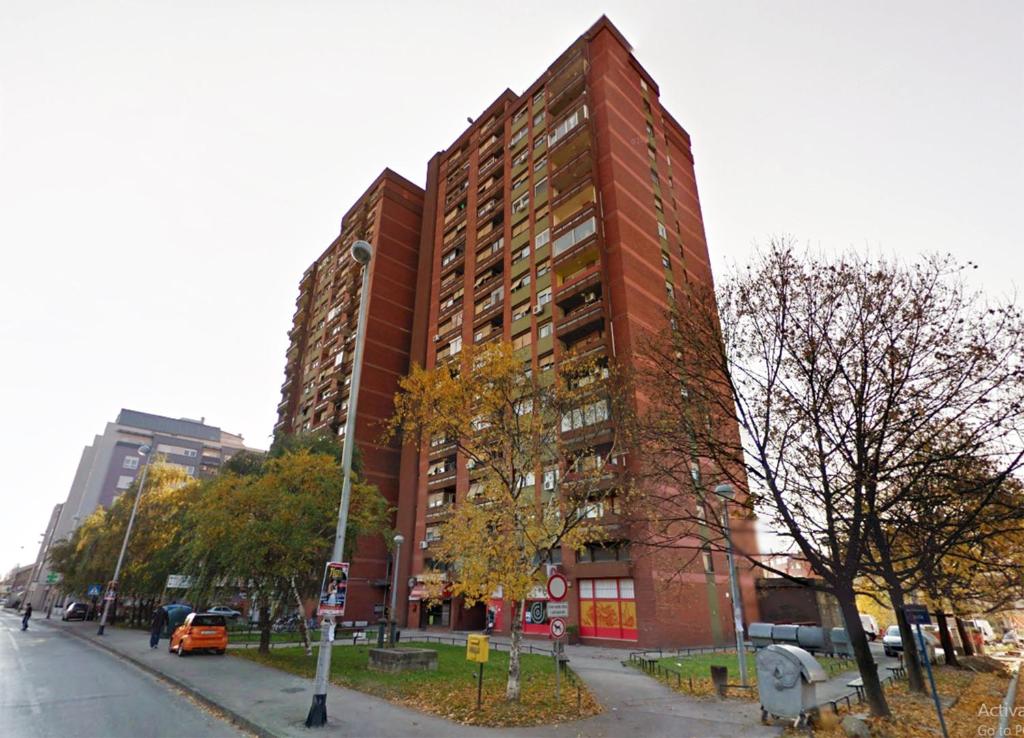 wysoki, czerwony, ceglany budynek na miejskiej ulicy w obiekcie Apartment Ciglica w Zagrzebiu