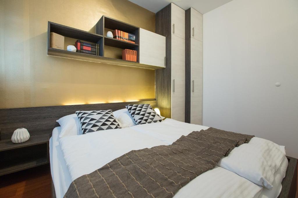 sypialnia z dużym łóżkiem z półką na ścianie w obiekcie Apartment Ciglica w Zagrzebiu