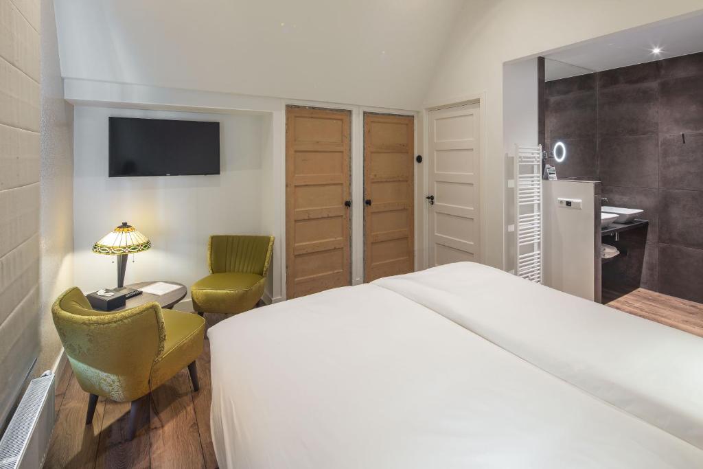 a bedroom with a bed and a desk and a chair at Het Polderhuis in Den Burg