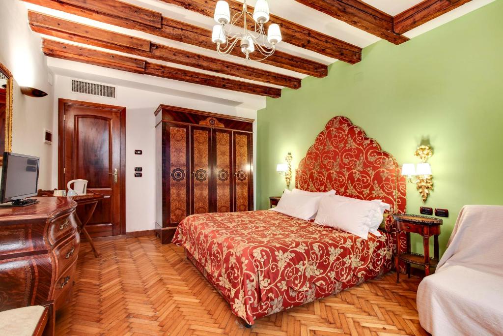 een slaapkamer met een bed, een bureau en een televisie bij San Marco Superior Apartments in Venetië
