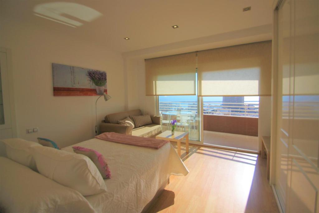 a bedroom with a bed and a couch and a window at Apartamento CasaTuris en el corazon de Alicante A118 in Alicante