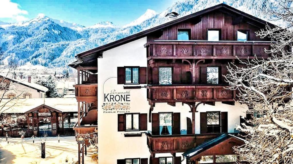 a building with a balcony with mountains in the background at Hotel Krone Tirol in Reutte