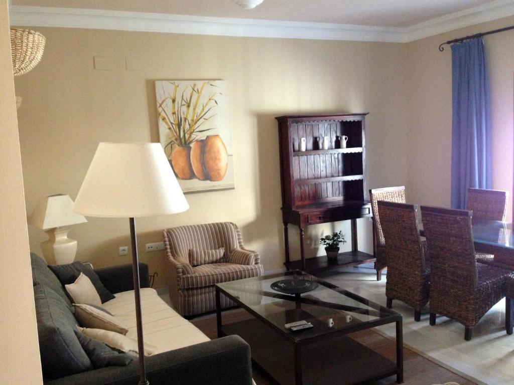 a living room with a couch and a table at Quartos City Apartments Carmona in Carmona
