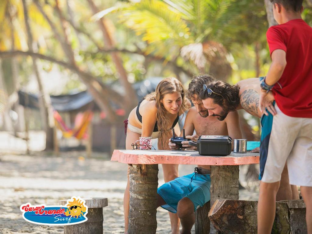 a group of people standing around a table at Casa Grande Surf in Guachaca