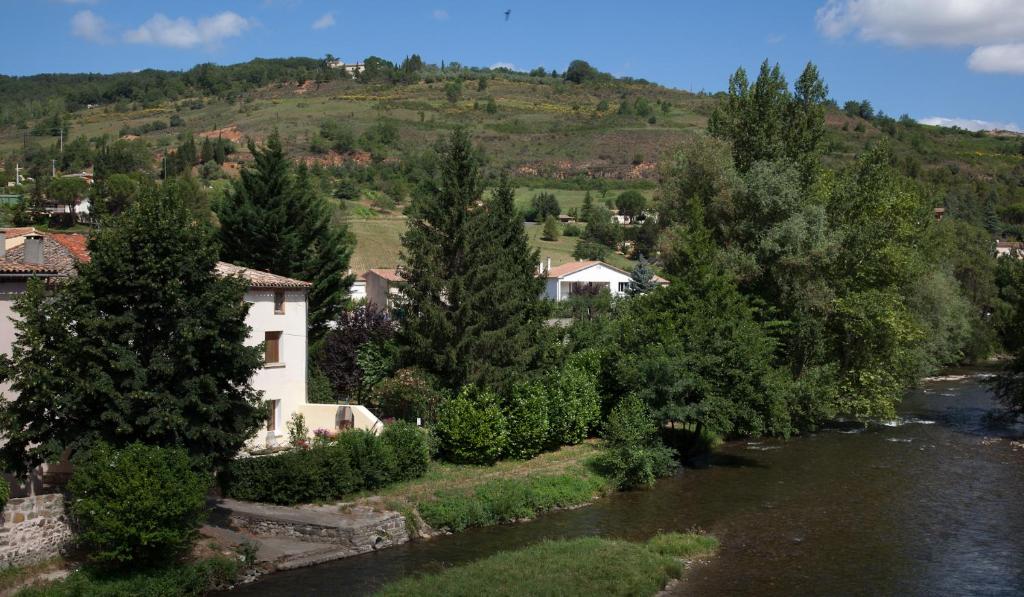 una casa junto a un río con árboles en LE CLOS DES COLVERTS, en Campagne-sur-Aude
