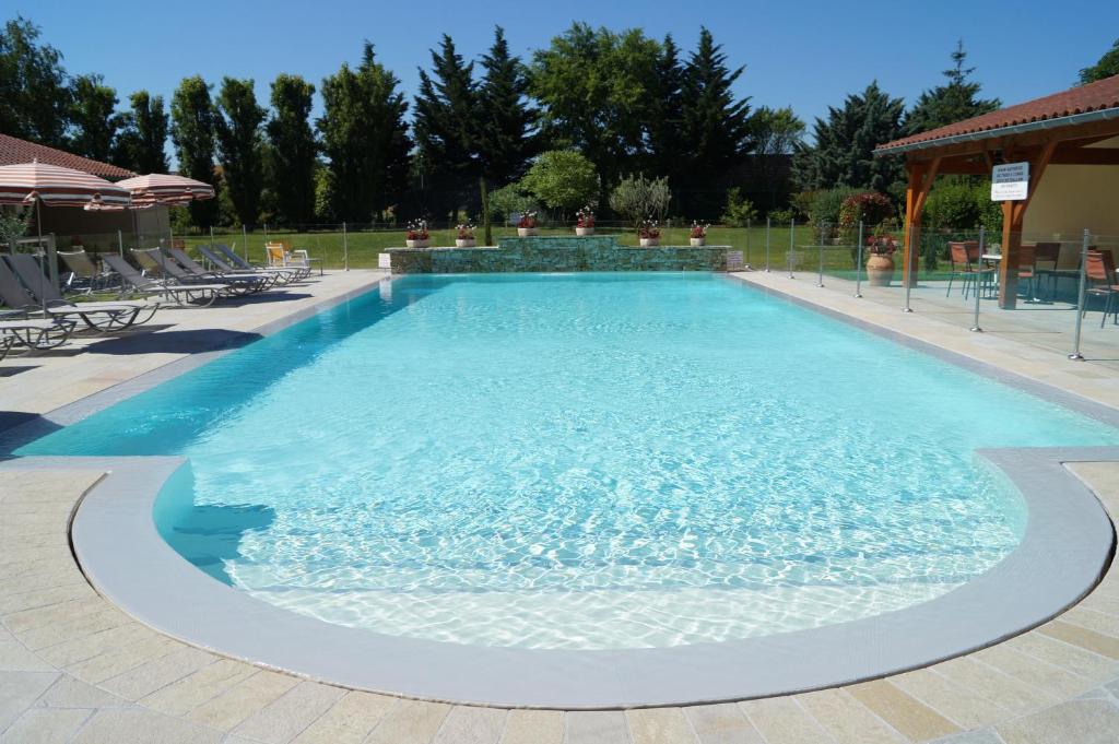 a large swimming pool with blue water at Hotel Restaurant La Martiniere in Montélier