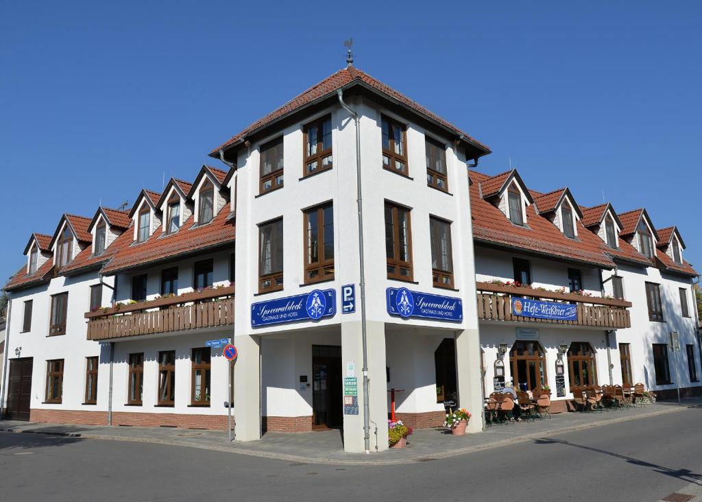 ein großes weißes Gebäude mit braunem Dach in der Unterkunft Hotel Spreewaldeck in Lübbenau