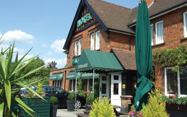 budynek z zielonym parasolem przed nim w obiekcie The Carre Arms Hotel & Restaurant w mieście Sleaford