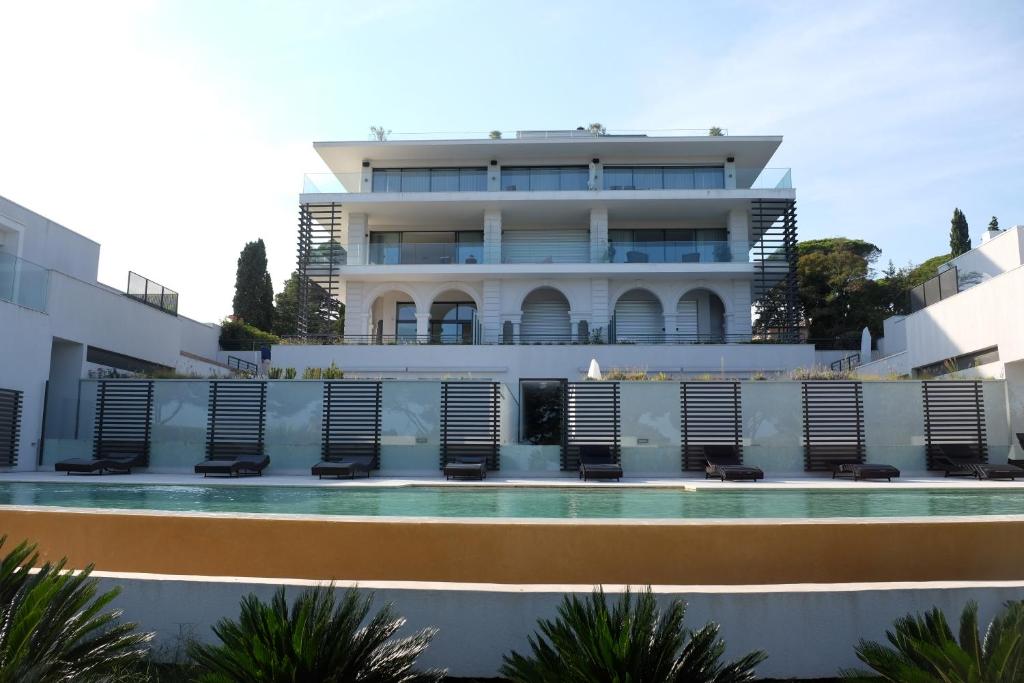 un edificio con piscina di fronte a un edificio di Villa Maxima a Sainte-Maxime