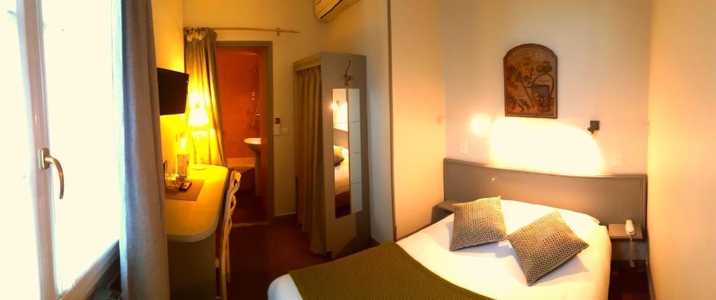 Uma cama ou camas num quarto em Hôtel du Parc