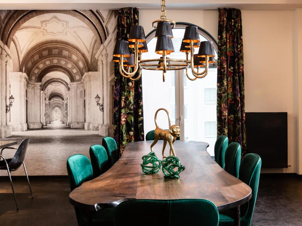 a dining room with a table with green chairs at Boutique Hotel K7 in Bad Nauheim