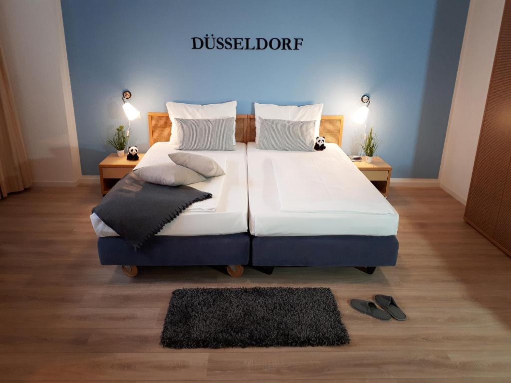 a bedroom with a large bed and two shoes on the floor at KEMPE Komfort Hotel in Düsseldorf
