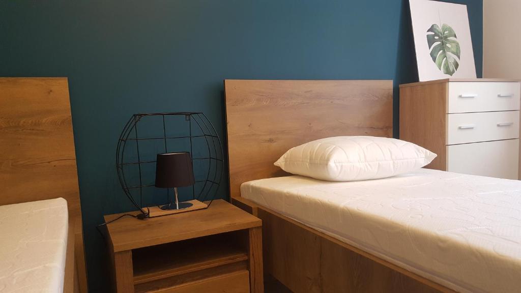 ein Schlafzimmer mit einem Bett und einem Nachttisch mit einer Lampe in der Unterkunft Pokoje Gościnne Plażowa in Białystok