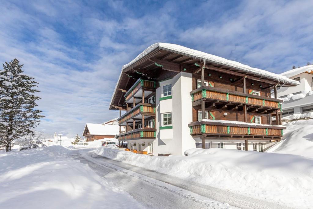 a building covered in snow with a road in front at Villa 7 in Flachau