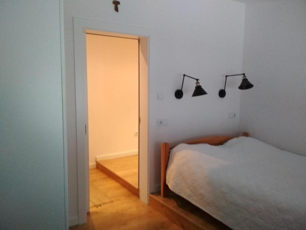 a bedroom with a bed and a door with lights at Apartament w Dolinie Popradu in Piwniczna-Zdrój