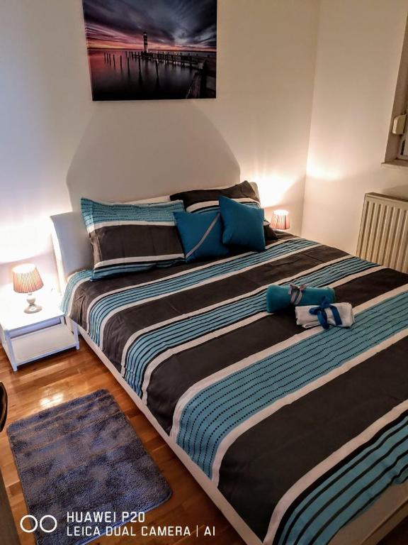 a bedroom with two beds with blue pillows at Apartman Kiss in Osijek