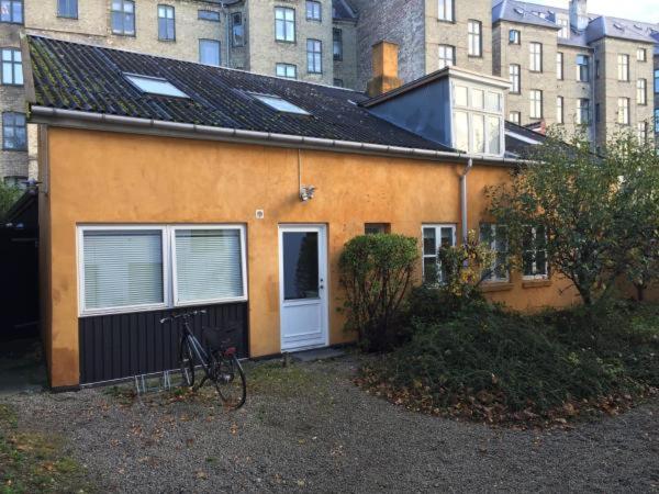 a house with a bike parked in front of it at Rooms in quiet Yellow Courtyard Apartment in Copenhagen