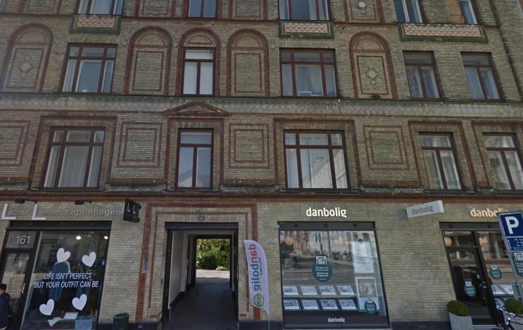 a large brick building with a doorway in front at Classic Brown Stone Apartment in Copenhagen