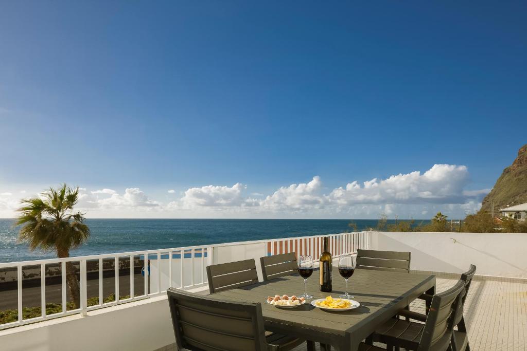 una mesa en un balcón con vistas al océano en CAPTAIN´S HOUSE, en Paul do Mar