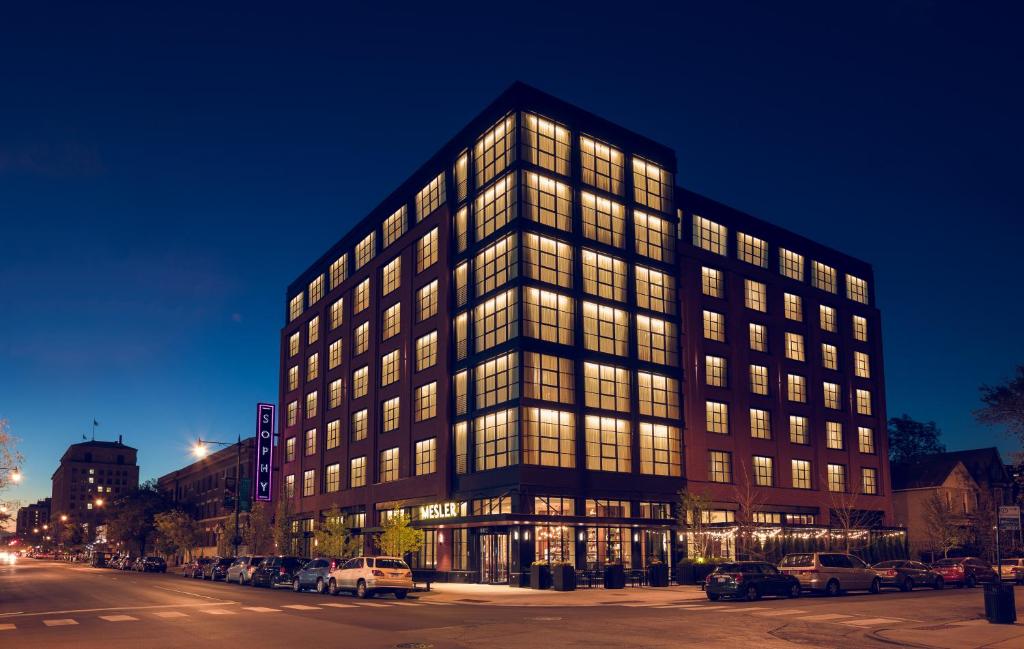 a large building with many windows at night at Sophy Hyde Park in Chicago