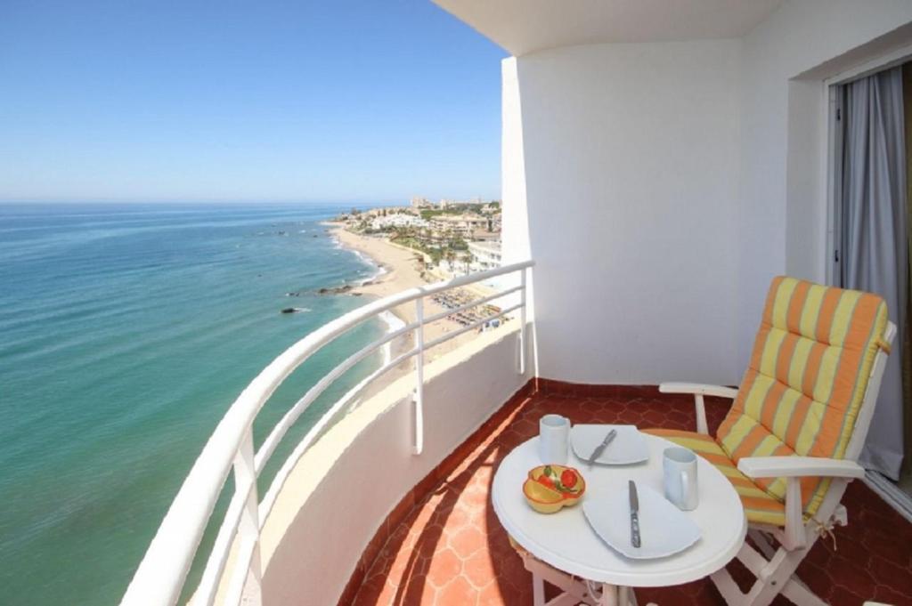 ein Balkon mit Tisch und Stühlen und dem Meer in der Unterkunft Rosa de los Vientos in Málaga