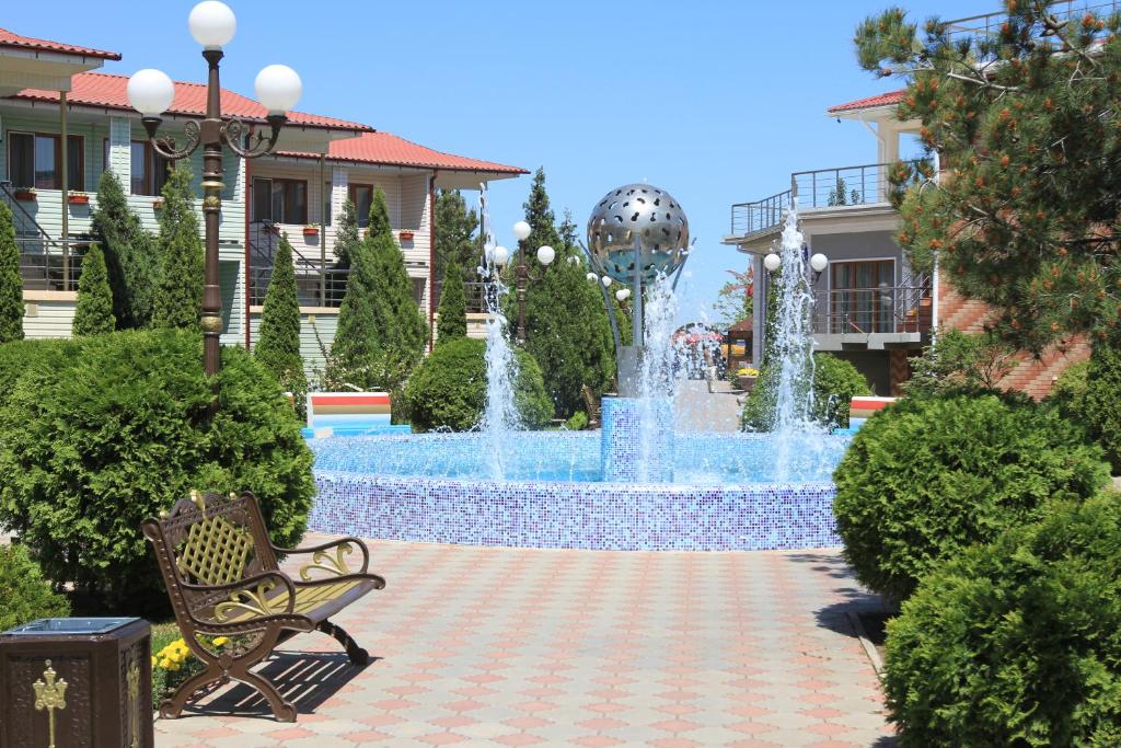una fuente en medio de un parque con un banco en Hotel Complex Djami, en Makhachkala