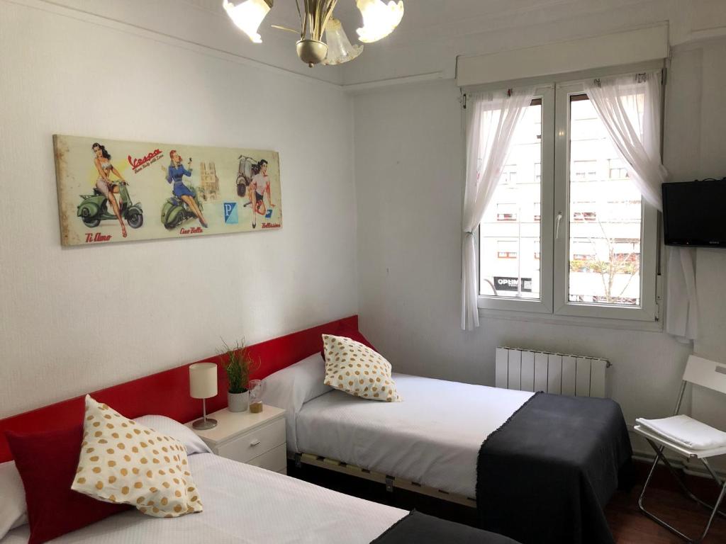 1 dormitorio con 2 camas y ventana en Pensión Arias, en Bilbao