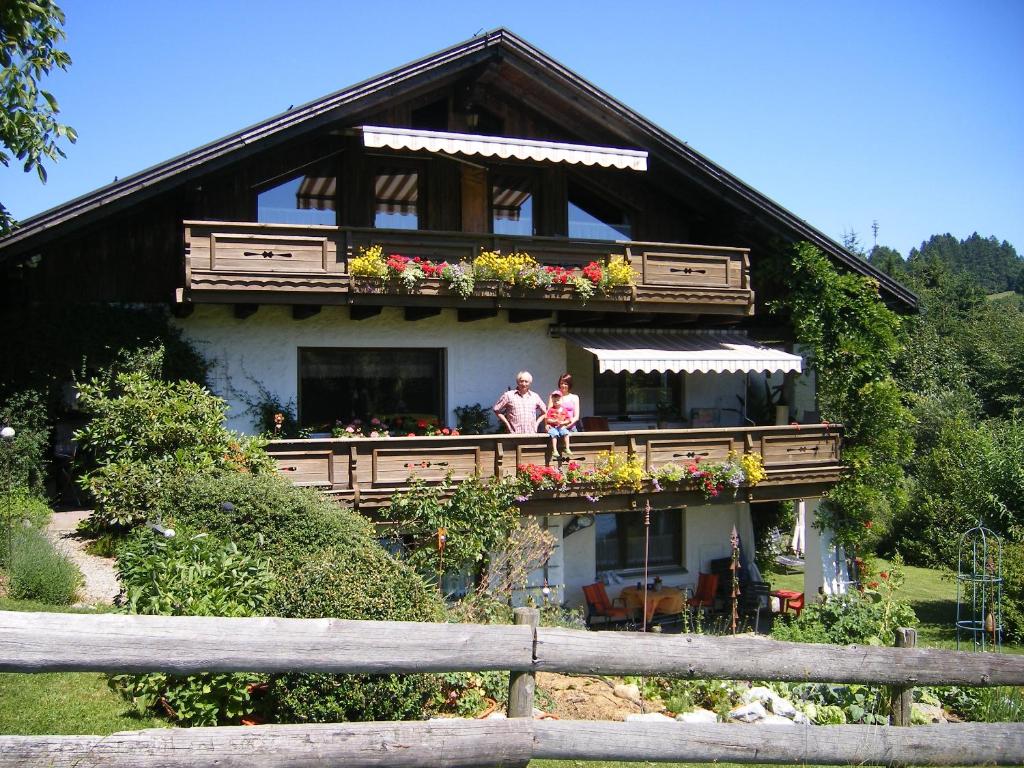 2 personnes debout sur le balcon d'une maison dans l'établissement Ferienwohnungen Frick, à Möggers