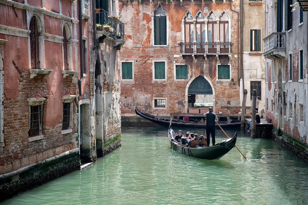 a group of people in a gondola in a canal at Hotel Mezzo Pozzo in Venice