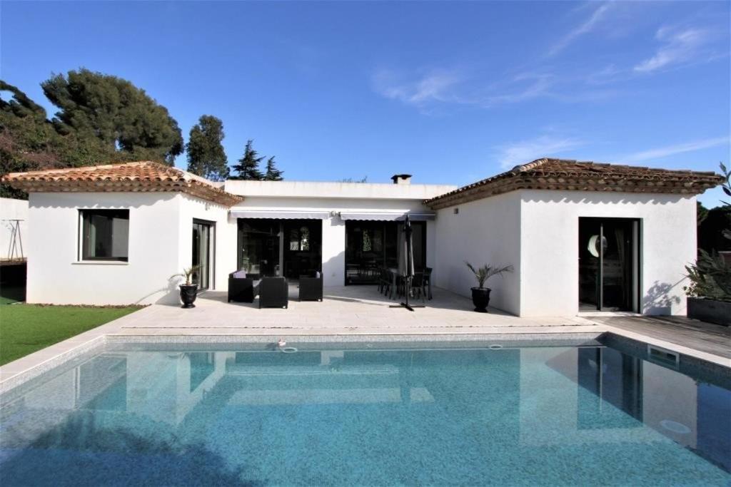 eine Villa mit einem Pool vor einem Haus in der Unterkunft Chemin de la Roseraie in Cavalaire-sur-Mer