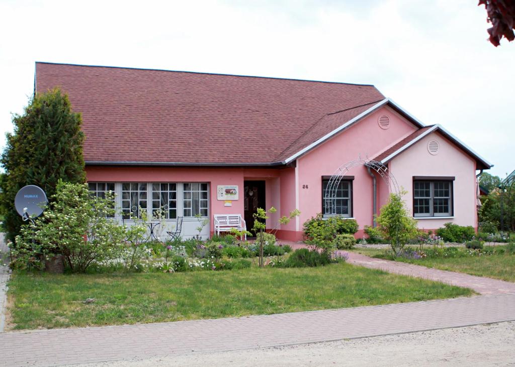 a pink house with a black roof at Ferienhaus Friedrichswalde in Friedrichswalde