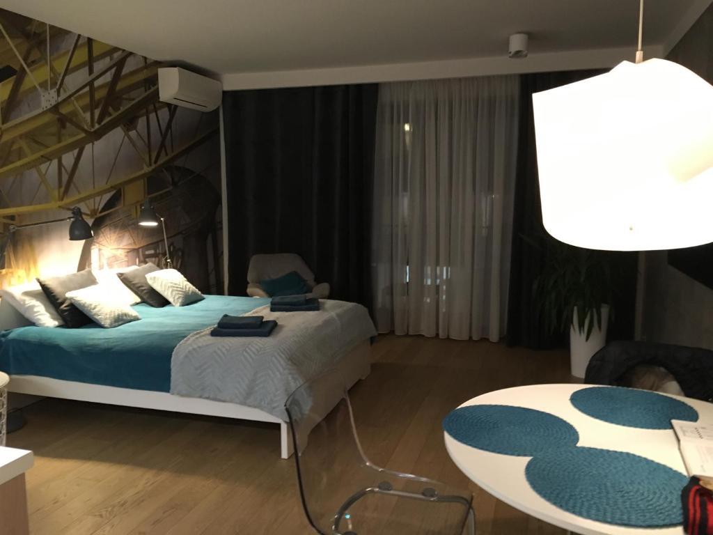 Apartment in the Gantry Hall - W19 في كراكوف: غرفة نوم فيها سرير وطاولة فيها