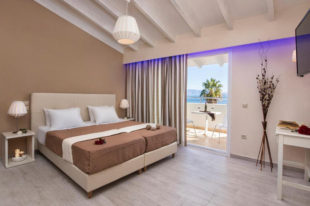 a bedroom with a bed and a view of the ocean at Onar Corfu Aparts & Studios in Ipsos
