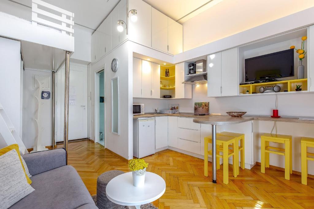 a kitchen and living room with a couch and a table at Studio apartman Piramida in Rijeka