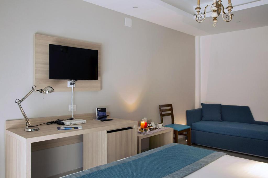 salon z telewizorem i niebieską kanapą w obiekcie American Hotel w mieście Pozzuoli