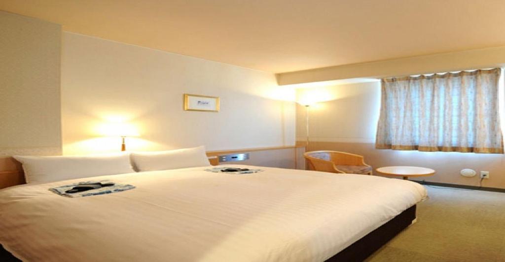 Habitación de hotel con cama grande y ventana en Hotel Benex Yonezawa / Vacation STAY 14346 en Yonezawa