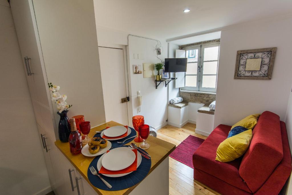- un salon avec une table et un canapé rouge dans l'établissement Allfado Apartments, à Lisbonne