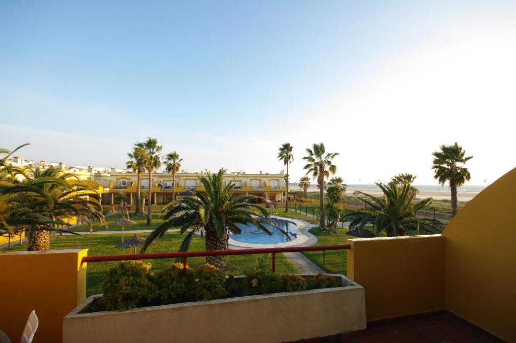 - une vue sur un complexe avec une piscine et des palmiers dans l'établissement Livingtarifa Apartamento Serendipia, à Tarifa