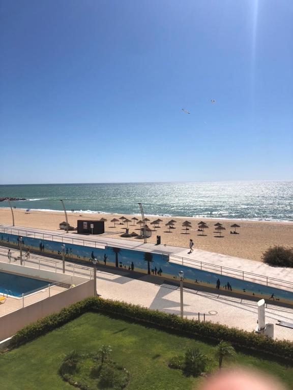 uma vista para a praia a partir da varanda de um resort em Apartment Girasol Front Beach Quarteira Algarve em Quarteira
