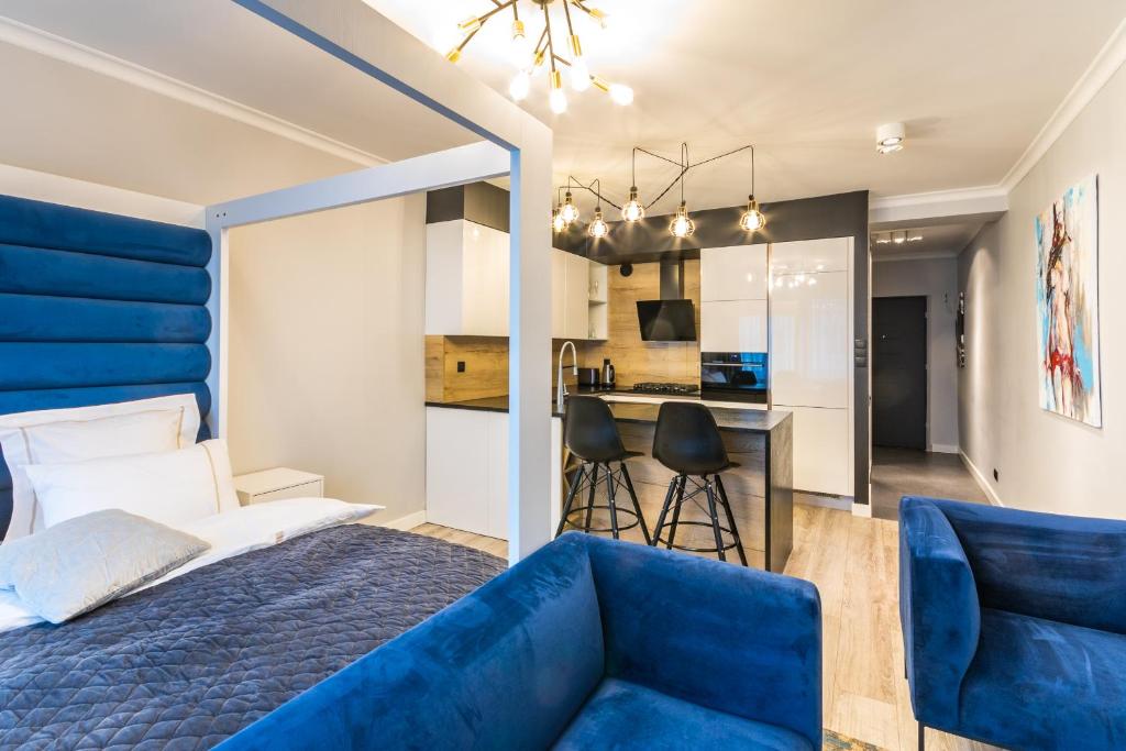 a bedroom with a blue bed and a blue couch at Fabulous apartment in heart of Katowice in Katowice