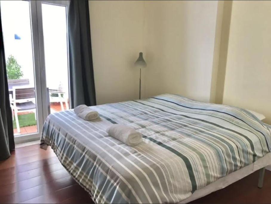- une chambre avec un lit et 2 serviettes dans l'établissement Amazing flat in Madragoa, à Lisbonne