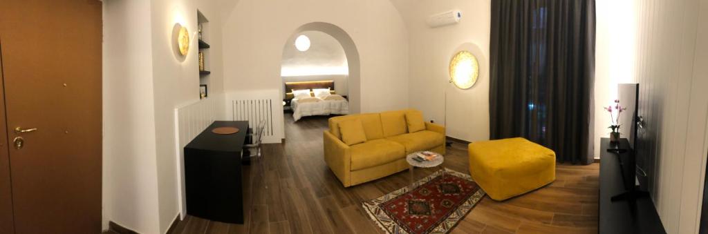 un soggiorno con sedia gialla e divano di Tropicana Room a Caserta